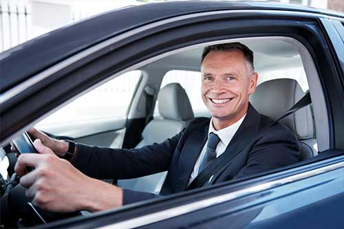 Man Smiling While Driving Car
