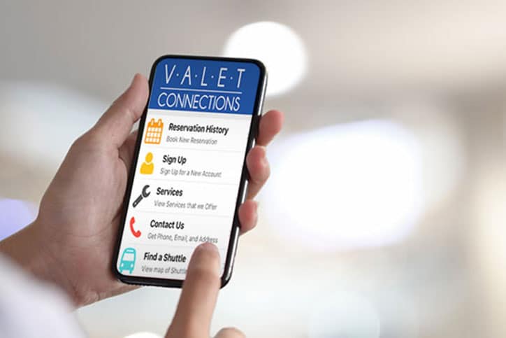 Hand holding phone and touching Valet Connections App.